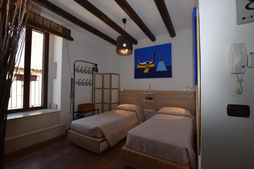 Un dormitorio con dos camas y una ventana. en Ciràsa, en Ragusa