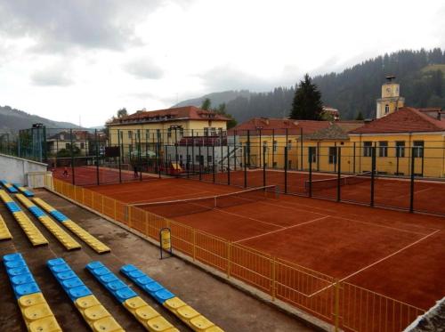 a tennis court with blue and yellow chairs on it at Къща за гости Малините in Chepelare