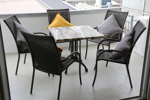 a table and chairs with pillows on a balcony at City Appartment Krefeld - 20 km DUS Airport/Messe in Krefeld