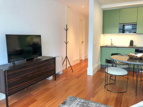 a living room with a television and a table with chairs at Oporto Chic&Cozy - Aliados in Porto