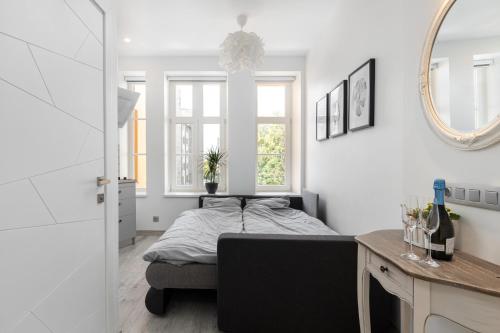 a bedroom with a bed and a desk and a mirror at Valdemāra Apartment in Rīga