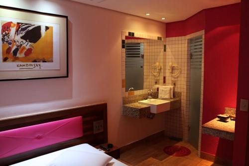 ein Bad mit einem Waschbecken und einem Spiegel in der Unterkunft Auhe Motel (Adults only) in Betim
