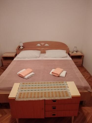 a bedroom with a large bed with two pillows at Soba Željka in Bribir