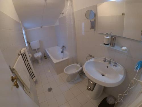 a white bathroom with a sink and a toilet at La Casa del Campanile in Summonte