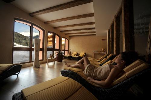 a man laying on a couch in a living room at Cerana Relax Hotel in Madonna di Campiglio