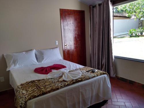 Un dormitorio con una cama con una camisa roja. en Pousada Bontempo, en Pirenópolis