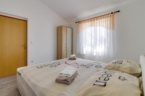 een slaapkamer met een groot bed met handdoeken erop bij Lovely VILLA Piljan with a private swimming POOL in Bokordići