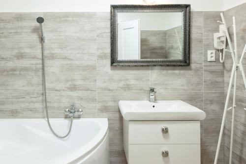 a bathroom with a sink and a toilet and a mirror at VILLA CENTRUM APARTMÁNY s RAŇAJKAMI A SAUNOU in Martin