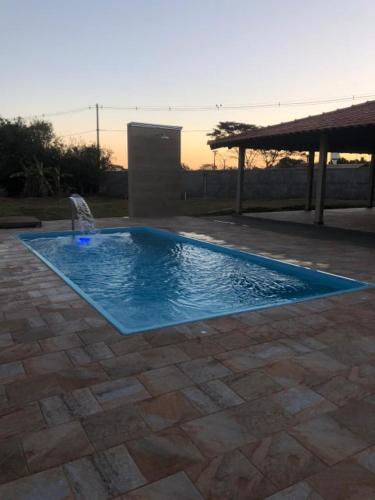 a swimming pool with a fountain in a yard at CANTINHO DO FOLCLORE nao alugamos para festas e eventos in Olímpia