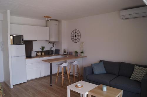 un salon avec un canapé et une cuisine dans l'établissement Port la Gavine vue mer, à Hyères