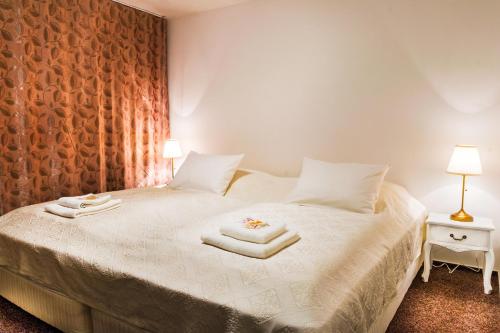 1 dormitorio con 1 cama con toallas en VILLA CENTRUM APARTMÁNY s RAŇAJKAMI A SAUNOU, en Martin