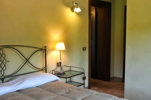 1 dormitorio con 1 cama y 1 mesa con lámpara en Villa Melagrana, en Fano