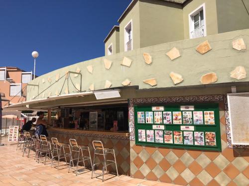 a restaurant with chairs in front of a building at Apartment Orlando Wave in Adeje