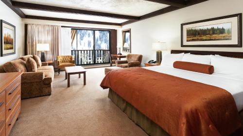 a hotel room with a large bed and a desk at Alta's Rustler Lodge in Alta