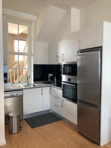 a kitchen with white cabinets and a stainless steel refrigerator at Carmo House in Braga