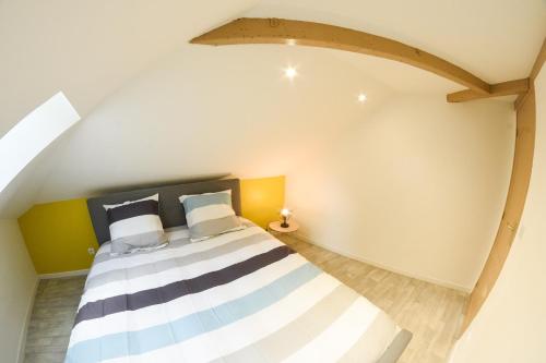 a bedroom with a striped bed in a attic at APPARTEMENT DU CENTRE in Charleville-Mézières