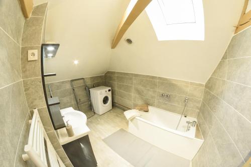 a bathroom with a tub and a toilet and a sink at APPARTEMENT DU CENTRE in Charleville-Mézières