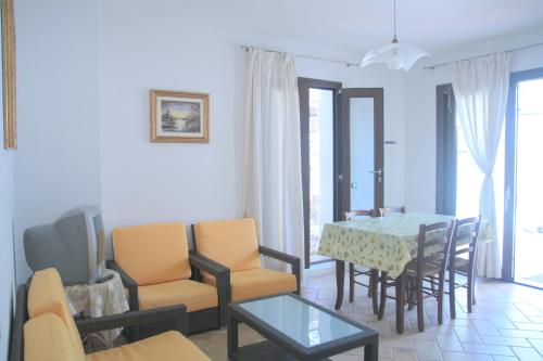 sala de estar con mesa de comedor y sillas en Casa al mare La Palma, en Santa Maria Navarrese