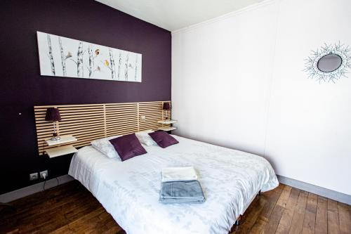 ポワティエにあるLes Trois Fontainesの紫の壁のベッドルーム1室(大型ベッド1台付)