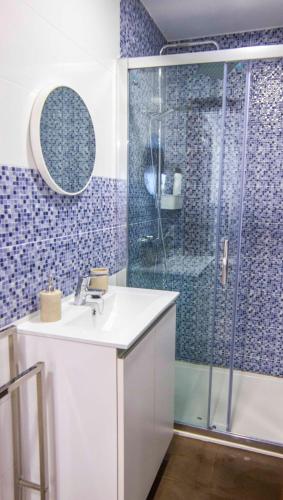 a bathroom with a white sink and a shower at Apartamento Mar de Fora in Finisterre