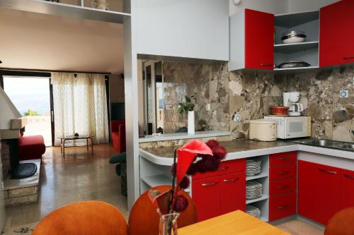 a kitchen with red cabinets and a living room at Apartments Aldica - 300 m from sea in Supetar