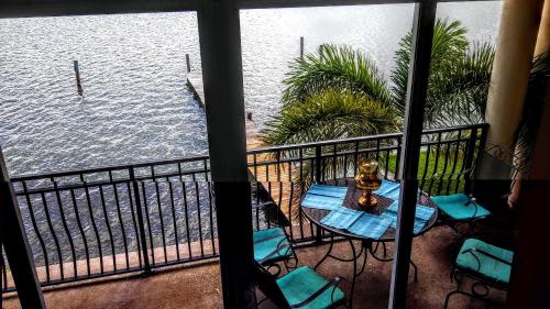 a balcony with a table and chairs and the water at Mediterranean Three Story Beach Townhouse in St Pete Beach