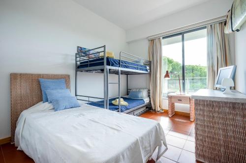 a bedroom with a bunk bed and a desk at Golf Residence Apartment in Vilamoura