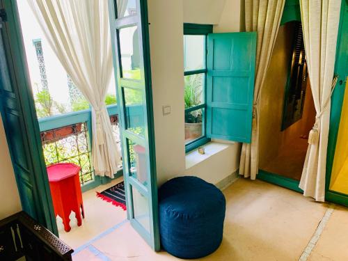 a room with a blue ottoman in front of a window at Riad 11 Zitoune in Marrakesh