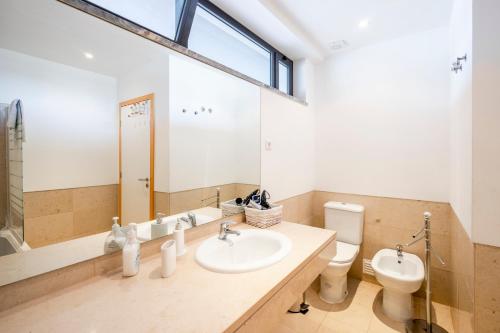 a bathroom with a sink and a toilet and a mirror at Golf Residence Apartment in Vilamoura