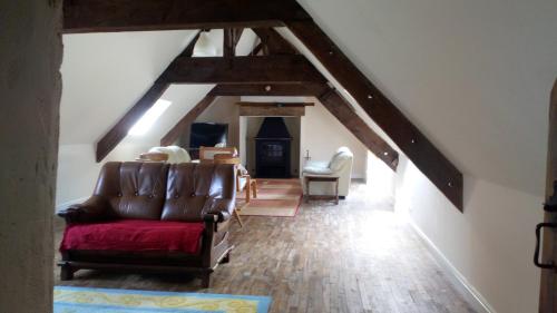 a living room with a couch in the attic at Caurelgranges in Caurel