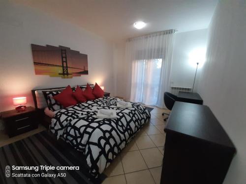a bedroom with a black and white bed with red pillows at Hillary E Vale Room in Rome