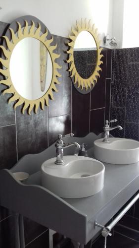 2 espejos sobre un lavabo en el baño en La Muscadîne, en Le Loroux-Bottereau