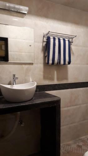 a bathroom with a white sink and a mirror at C Pearl in Majorda