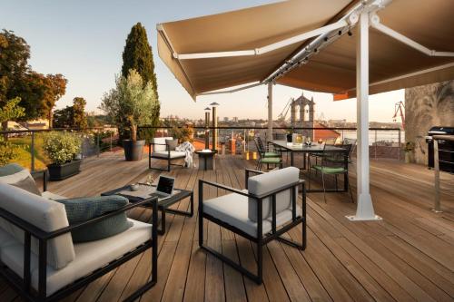 a deck with chairs and tables on top of a building at Apartment Altana with free parking in Pula