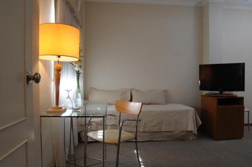a bedroom with a bed and a table with a laptop at Parra Hotel & Suites in Rafaela