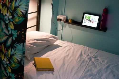 a bedroom with a bed with a book on it at NATIVUS Art-Hostel in San José