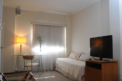 a hotel room with a bed and a television at Parra Hotel & Suites in Rafaela