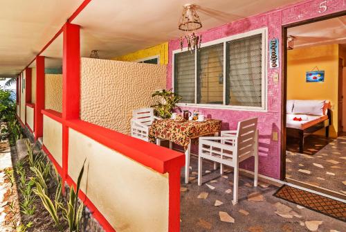 einen Tisch und Stühle auf der Veranda eines Hauses in der Unterkunft Kurma Eco Beach Lodge in Mambajao
