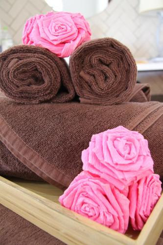 three rolls of brown and pink towels on a tray at Peppercorn Beach Resort in Phu Quoc