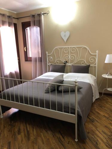 a bedroom with a white bed with a heart on the wall at B&B Martina in Assemini