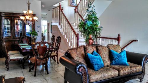 a living room with a couch with blue pillows at Mediterranean Three Story Beach Townhouse in St Pete Beach