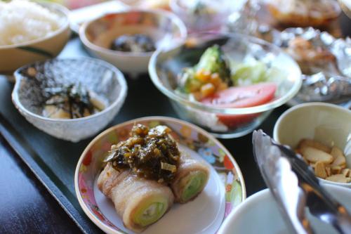 a table with plates of food and bowls of food at Kozaemon in Gujo