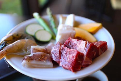 a plate of food with meat and vegetables on a table at Kozaemon in Gujo
