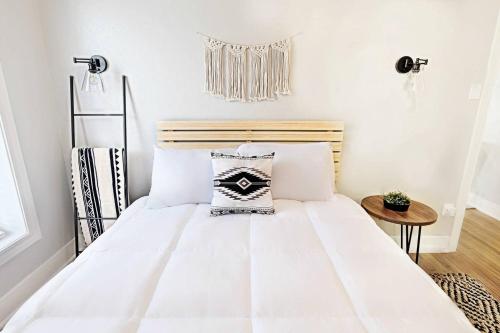a bedroom with a white bed with a wooden headboard at Our Nest on Vickery in Dallas