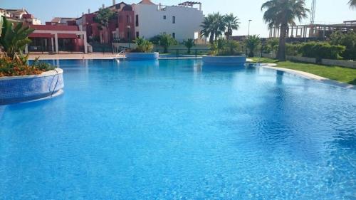 a large swimming pool with blue water at Apartamento Ayamonte golf Costa Esuri in Ayamonte