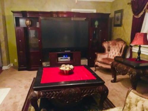 uma sala de estar com uma televisão grande e uma mesa vermelha em BEST DEAL IN TOWN! Entire 1 Bedroom Apartment 59 em Montgomery