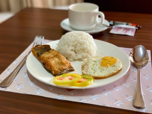 a plate of food on a table with rice at Davao Persimmon Suites in Davao City
