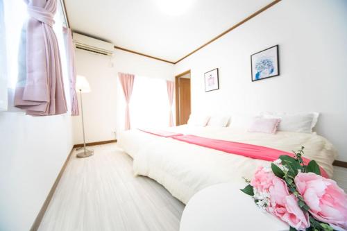 a bedroom with two beds and pink flowers in it at Awaji Seaside Resort in Iwaya 3000 in Awaji