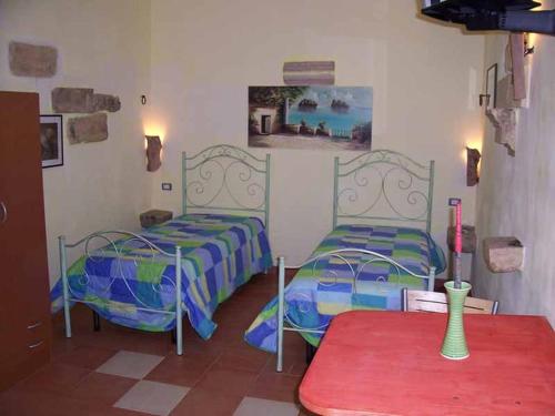 Habitación con 2 camas y mesa roja. en Le Camporelle In Campagna, en Cavallino di Lecce