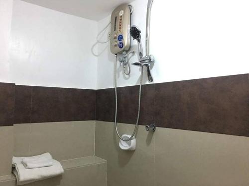 a shower in a bathroom with a phone on the wall at Zoom BnB in Naga